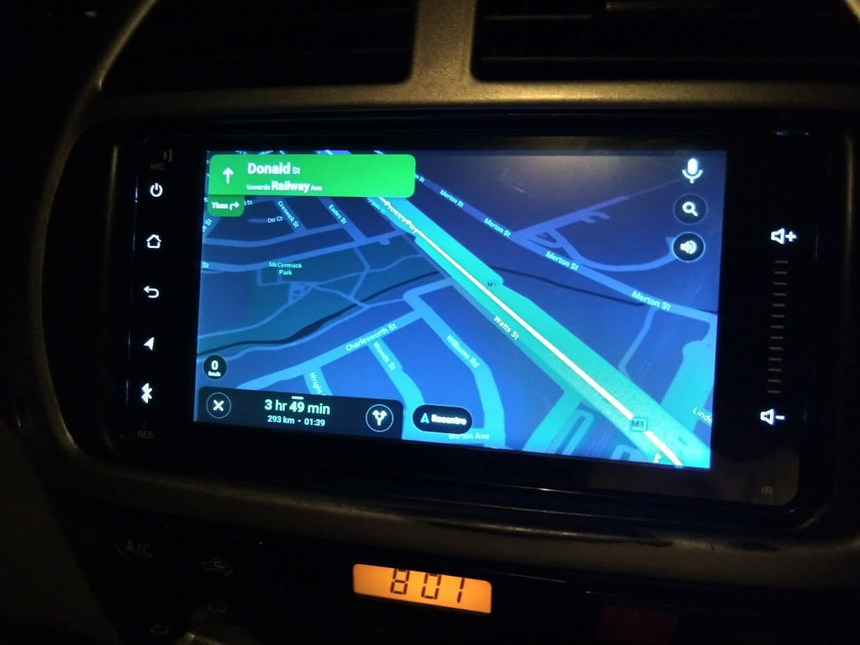 A LCD screen mounted in a car showing an Android Auto maps display